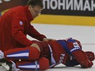 V PÉI LÉKAE. Ruský hokejista Alexej Treenko zstal po sráce leet na led a musel k nmu pispchat doktor.