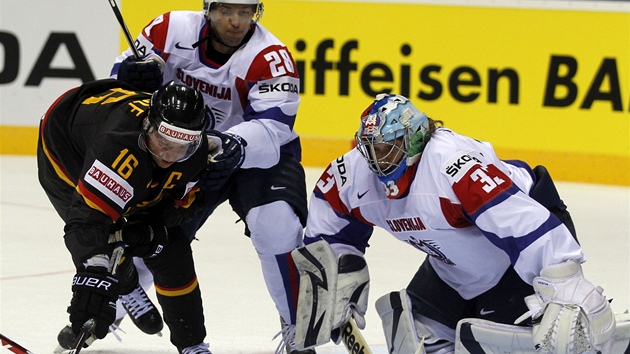 N�mecký bojovník Michael Wolf se sna�í p�es obránce Slovinska Alese Kranlce prosadit p�ed gólmanem Robertem Kristanem.
