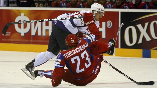 TVRDÁ SRÁŽKA. Ruský hokejista Alexej Těreščenko padá na led po srážce se slovinským soupeřem Robertem Saboličem.