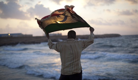 Obyvatel Benghází s vlajkou Libye z dob monarchie (11. kvtna 2011)