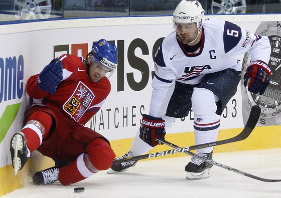 FOTBAL? Hokejový útočník Petr Hubáček se snaží odkopnout puk před americkým kapitánem Markem Stuartem.