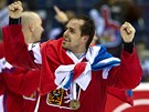 JO! Kapitán českých hokejistů Tomáš Rolinek s vlajkou kolem krku a bronzovou medailí na něm.