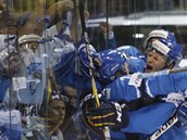 MODRÁ A BÍLÁ. Hokejisté Finska slaví na leě, fanoušci hned za plexisklem.