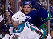 Dany Heatley ze San Jose (v blm dresu) atakuje vancouverskho Alexandra Edlera.