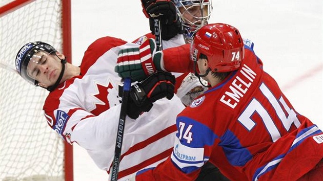 Ruský obránce Alexej Jemelin atakuje Kanaďana Johna Tavarese.