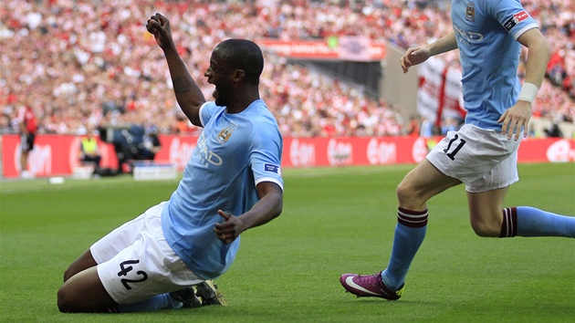 RADOST NA KOLENOU. Yaya Touré z Manchesteru City se raduje, práv� vst�elil jedinou branku ve finále FA Cupu. Slavit p�ibíhá i Adam Johnson.