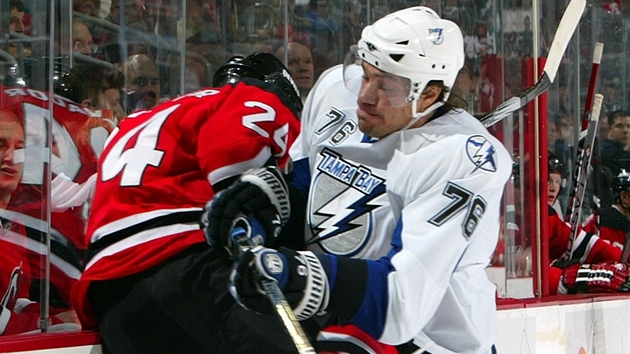 Takhle ho zná hokejový svt nejvíc: Jevgenij Aruchin v dresu Tampa Bay Lightning naráí na mantinel soupee z New Jersey Devils.