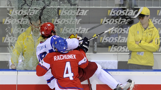 TISÍC ST�EP�. �eský obránce Karel Rach�nek se v bitv� o bronzovou medaili pomstil Jevgeniji Ar�uchinovi za atak v p�edchozím vzájemném zápase. S ruským obrem pra�til o mantinel tak drsn�, a� se vysypalo tvrzené sklo.