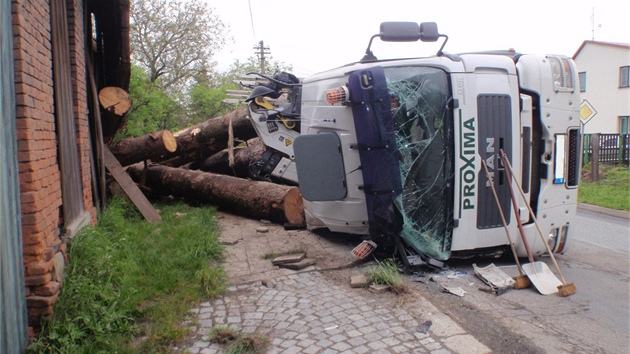 Nehoda v Osíku na Kromísku, pi které se v zatáce pevrátilo nákladní auto naloené kládami na bok. Z korby se pak kmeny uvolnily a mimo jiné zboily ást stodoly u silnice.
