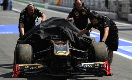 Mechanici Renaultu tlaí ohoelý monopost Nicka Heidfelda do box.