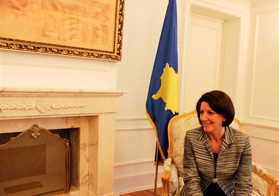 Kosovská prezidentka Atifete Jahjagová, za ní kosovská vlajka, vlevo na zdi kosovská ústava