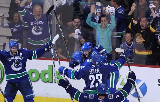 TADY JSEM. Stelec vyrovnávacího vancouverského gólu proti San Jose na 2:2 Ryan Kesler stojí vlevo, zatímco jeho spoluhrái se objímají. Gratulace ho vak neminula, vdy svou trefou si vynutil prodlouení.