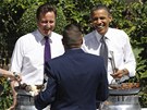 Britský premiér David Cameron (vlevo) a americký prezident Barack Obama servírovali v Downing Street klobásy a hamburgery pro veterány (25. kvtna 2011)