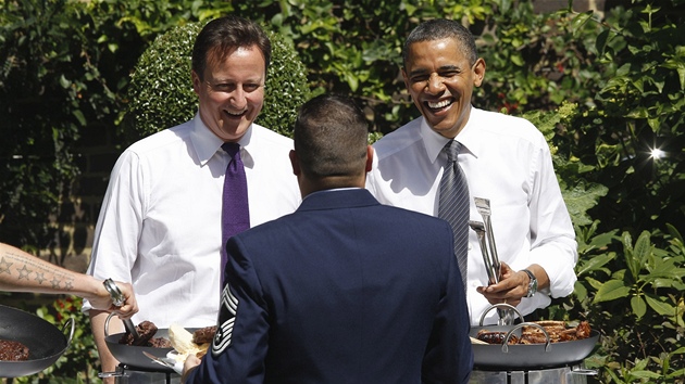 Britský premiér David Cameron (vlevo) a americký prezident Barack Obama servírovali v Downing Street klobásy a hamburgery pro veterány (25. kvtna 2011)