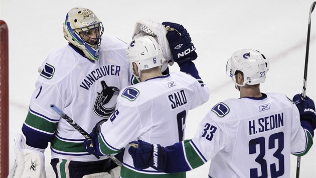DÍKY ZA PODPORU. Sami Salo a Henrik Sedin p�ijí�d�jí pogratulovat branká�i Robertu Luongovi za jeho práci zejména v první t�etin�, kdy spoluhrá�e z Vancouveru vzadu podr�el a oni pak na oplátku zdolali San Jose 4:2.
