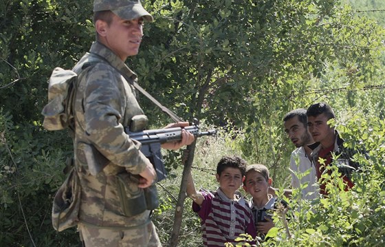 Turecký voják se skupinkou syrských uprchlík, kteí ekají na povolení vstupu do Turecka. (9. ervna 2011)