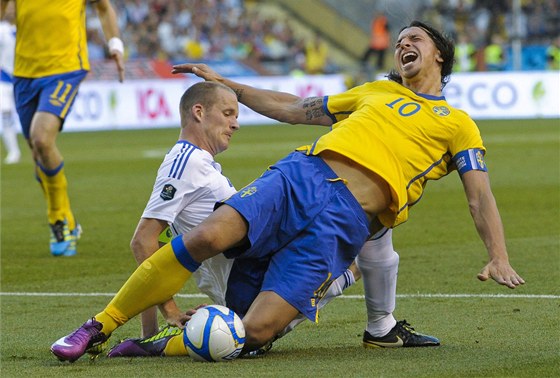 védský útoník Zlatan Ibrahimovic padá po faulu Petriho Pasanena z Finska.