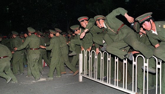 Čínští vojáci přeskakují zátarasy a vyráží proti demonstrantům na Tchien-an-men...
