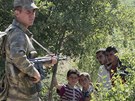 Turecký voják se skupinkou syrských uprchlík, kteí ekají na povolení vstupu do Turecka. (9. ervna 2011)