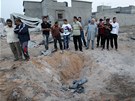 Libyjci postávají nad kráterem, v nm má podle vládní propagandy leet zbytek bomby NATO 