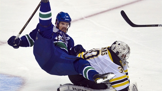 TVRDÝ STET. Útoník Vancouver Daniel Sedin padá pes brankáe Bostonu Tima Thomase.