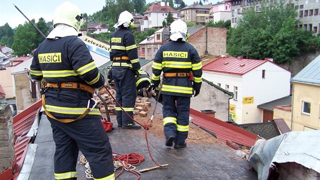 Hasii odstraují pokozenou stechu z domu v Úpici. (8. ervna 2011)