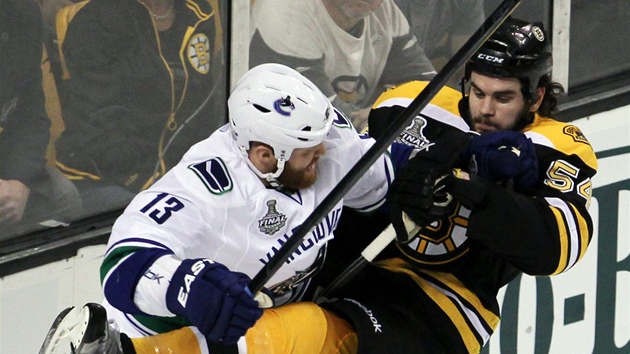 Adam McQuaid (vpravo) z Bostonu elí ataku vancouverského Adama McQuaida.  