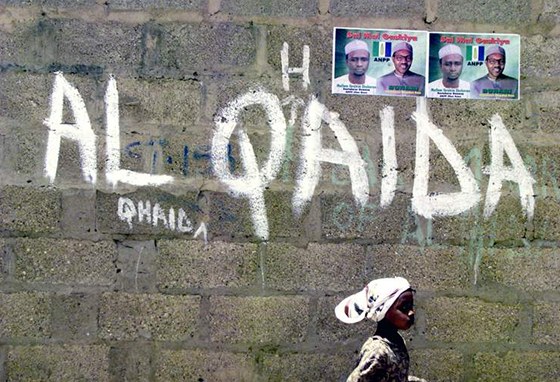 Nigerijská dívka prochází kolem nápisu Al-Káida napsaném na zdi ve mst Kano.