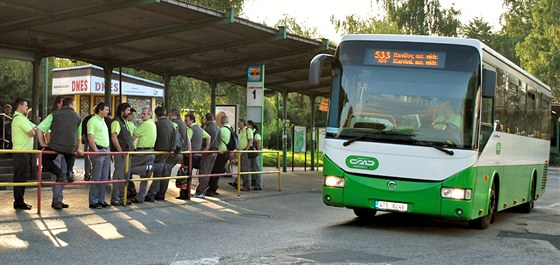 Stávkující řidiči ČSAD Havířov shromáždění před výpravní budovou sledují autobus se řidičem, který se rozhodl do protestu nezapojit. (16. června 2011)