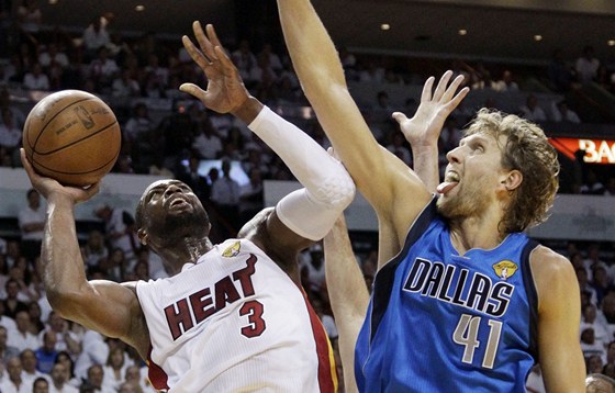 Dwyane Wade (vlevo) z Miami zakonuje pes Dirka Nowitzkého z Dallasu.