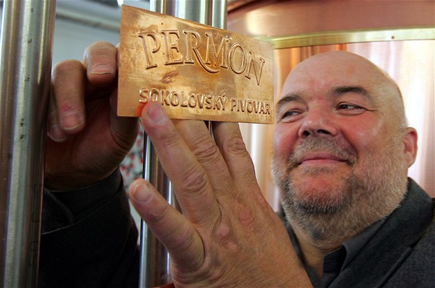 editel Ladislav Sás upevuje mosaznou cedulku pivovar Permon. 