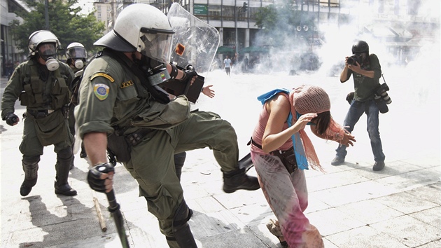Řecký policista nevybíravě nakopává jednu z demonstrujících 