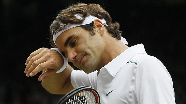 STAROSTI. Roger Federer si utírá pot z ela pi tvrtfinále Wimbledonu