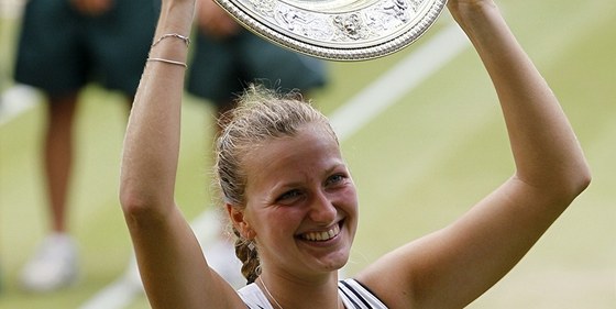 VYSNNÁ TROFEJ. Petra Kvitová zvedá nad hlavu trofej pro vítzku Wimbledonu.