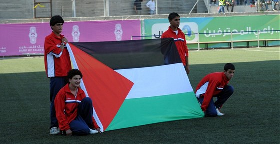 Chlapci drí palestinskou vlajku ped kvalifikaním utkáním s Bahrajnem, které