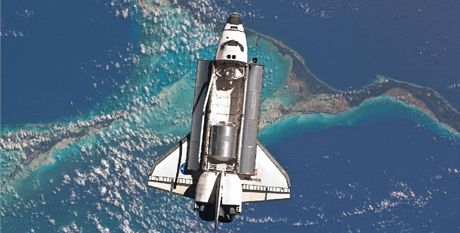 Atlantis nad Bahamskými ostrovy míí naposledy k iSS. Na okraji snímku je zaparkovaná kosmická lo Progress.