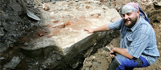 Archeolog Michal Soukup ukazuje ve výkopu pro novou fontánu portál pouitý v