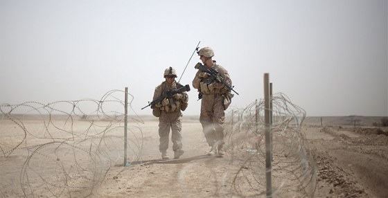 Americký voják a vojaka jdou nedaleko vesnice Shir Ghazay v provincii Hílmand