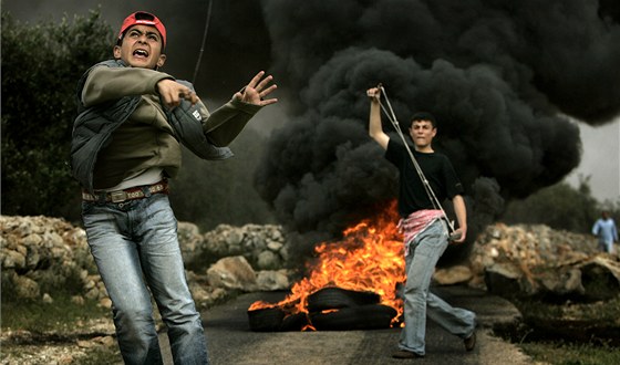 Palestinský chlapec na archivním snímku háe kamení po izralském policistovi