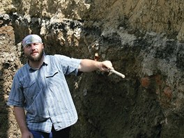 Archeolog Michal Soukup ukazuje ve vkopu pro novou fontnu silnici z poloviny