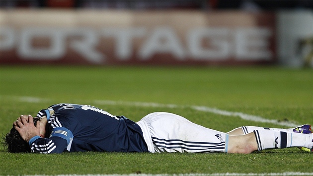 ... To argentinská hv�zda Lionel Messi le�í na trávníku, obli�ej schovává. Jeho