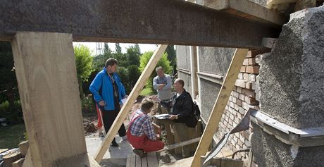 Stavebníci pracují za zajitní zborcené zdi bytového domu ve Zbchu
