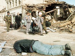 Srbt vojci a civilist prochz rozstlenm Vukovarem. Archivn snmek z 