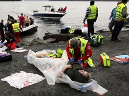 Záchranáři pomáhají lidem poraněným při střelbě na norském ostrově Utoya (22.