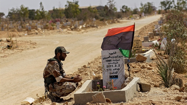Libyjský rebel sedí u hrobu svého spolubojovníka v Benghází (21. ervence