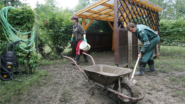 Úklid zahrady u zatopeného domu Václava Švarce v Cháborech, kam se vylila