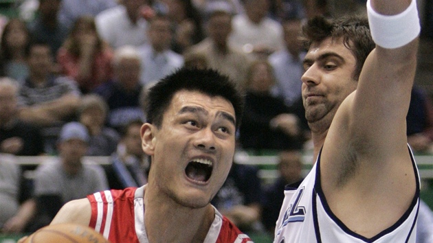 Jao Ming (vlevo) v dresu Houstonu Rockets proniká kolem Mehmeta Okura z Utahu...
