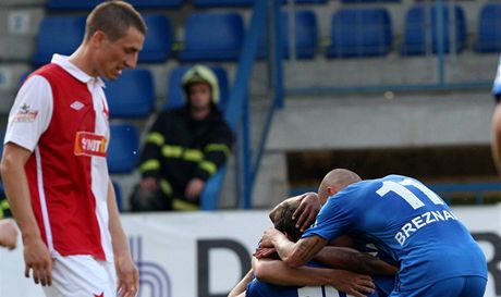 KONTRAST. Zatímco se fotbalisté Liberce radují z gólu, tak kolem prochází