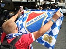 BANÍK! Fanouek ostravských fotbalist mává na olomouckém nádraí vlajkou svého