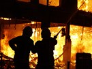 Londýntí hasii se snaí uhasit budovu, kterou zapálili demonstranti v